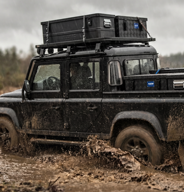 Geländewagen mit ALUTEC EXTREME BLACK Dachboxen bei Outdooreinsatz auf Schlammpiste